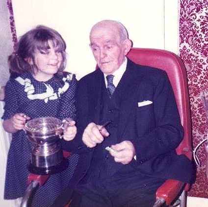 Geradine Baird's Dad, Pat Kerlin, With Her Daughter Katie And His Prize For Fruit And Veg Growing, Early 1980S. Courtesy Of Geraldine Baird image